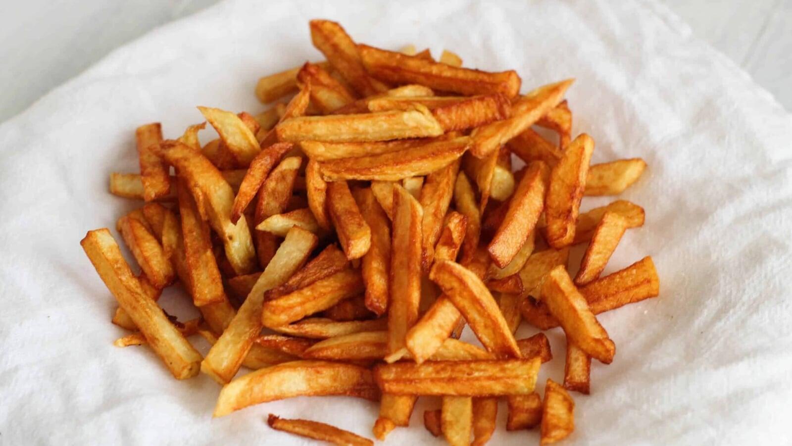 Pile of golden French fries fried in beef tallow.
